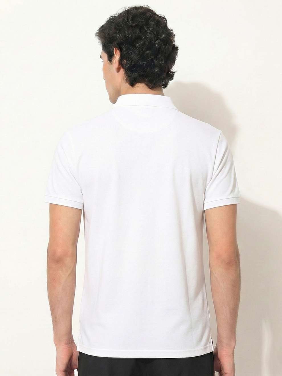 Person wearing a white t-shirt against a plain background