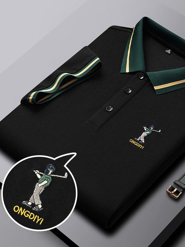 Black polo shirt with green accents and embroidered design on a gray surface