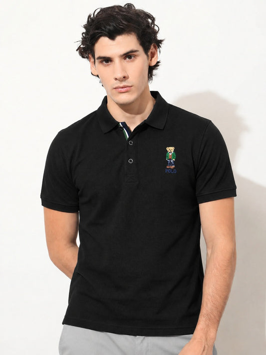 Man wearing a black polo shirt with a logo on a white background