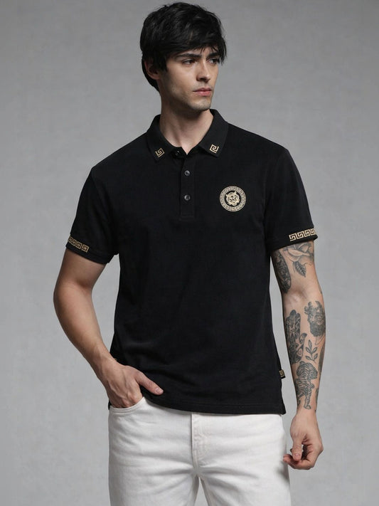 Man wearing a black polo shirt with gold accents on a gray background