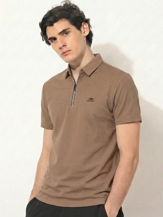 Man wearing a brown polo shirt with a logo on a white background