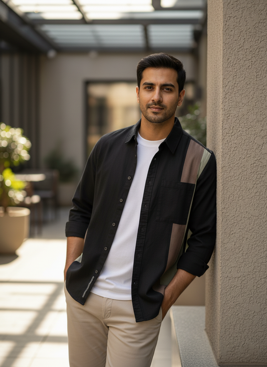 Man standing outdoors in a modern setting with plants and architectural elements.