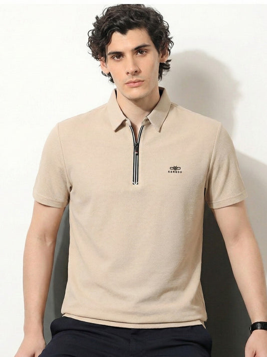 Man wearing a beige polo shirt with a zipper and logo on a white background