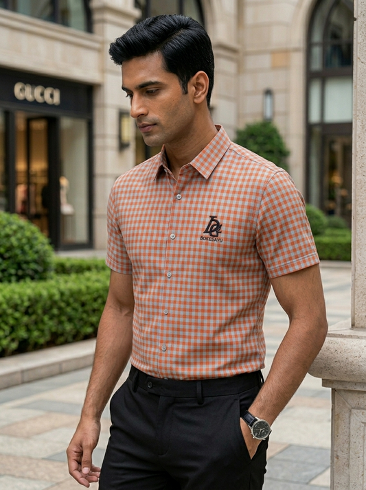 Man wearing a checkered shirt with a brand logo in an urban setting