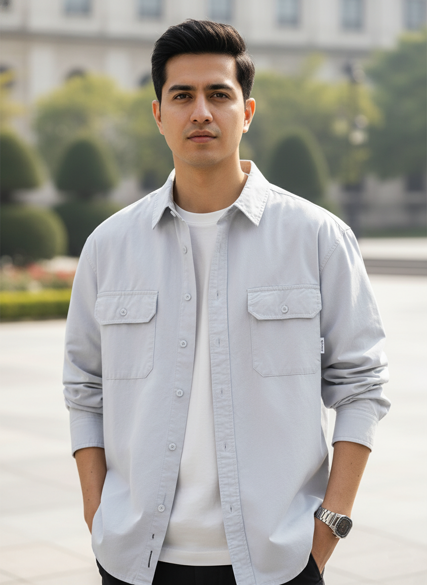 Man wearing a light gray shirt with a blurred background