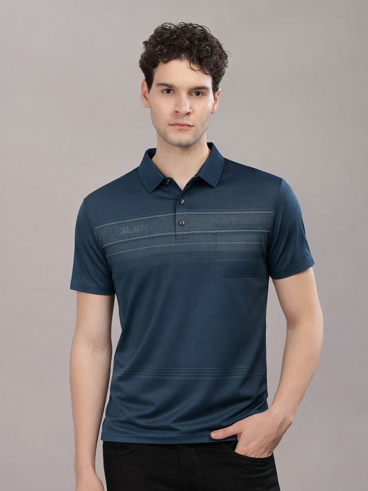 Man wearing a navy blue polo shirt against a gray background