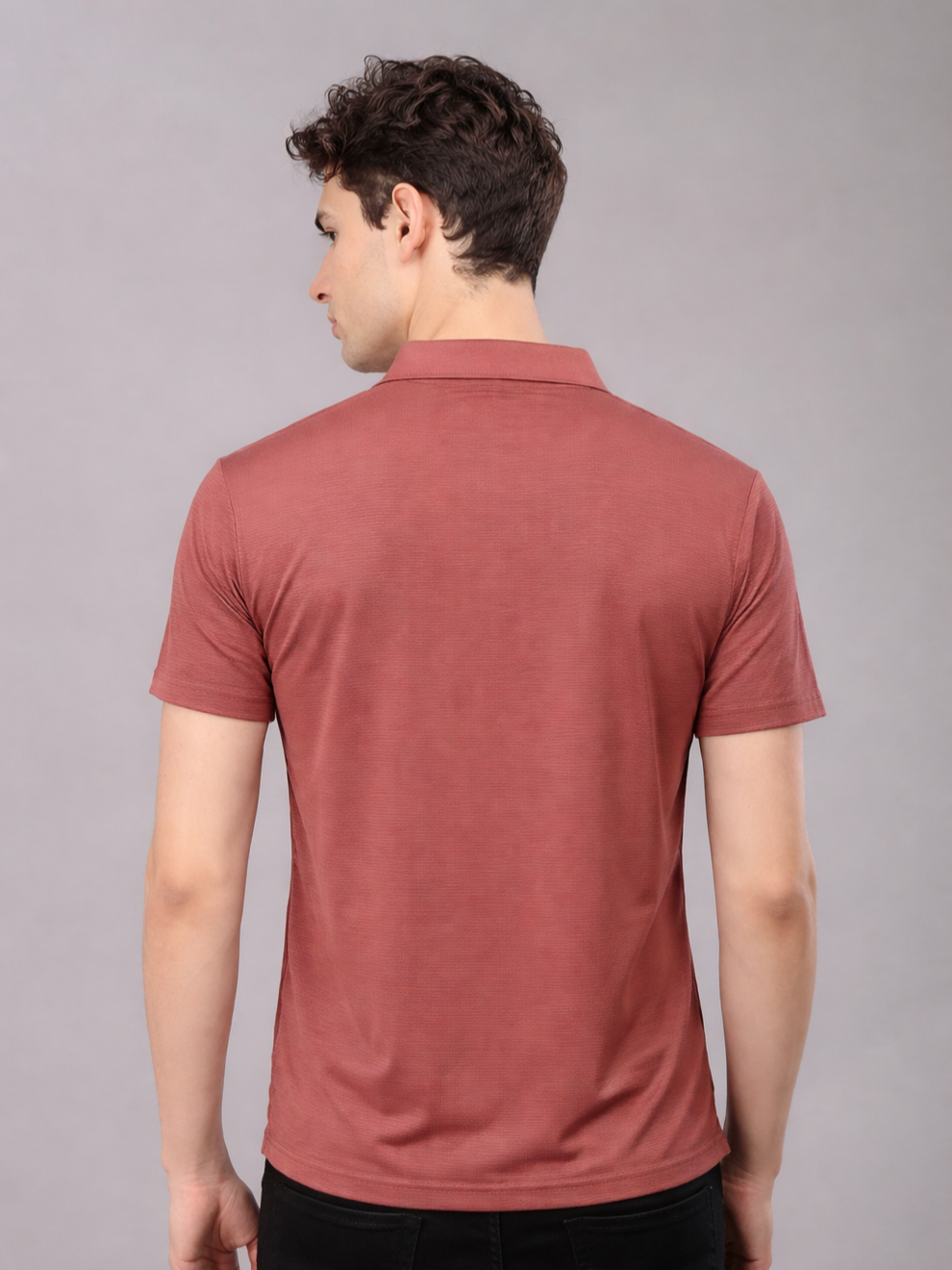 Man wearing a red polo shirt against a gray background