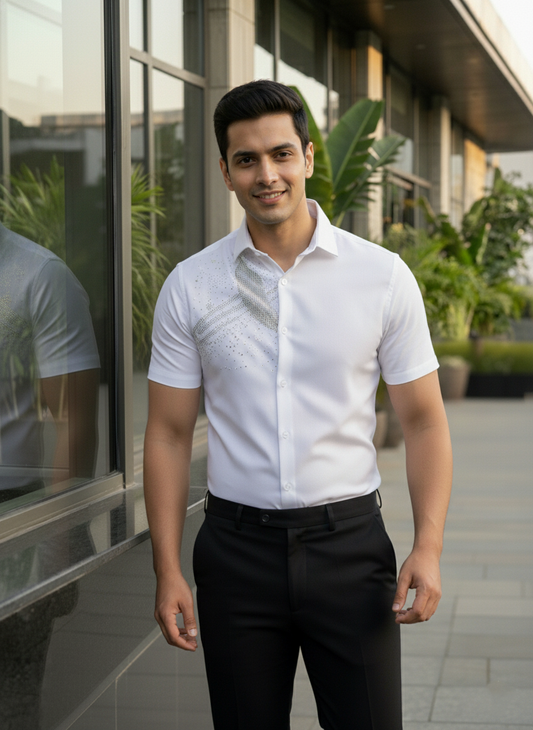 Man wearing a white short-sleeve shirt with black pants standing in front of a modern building.