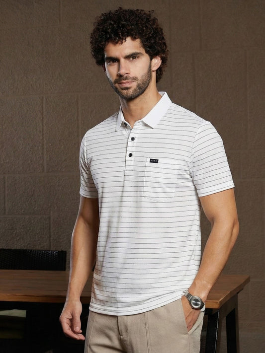 Man wearing a white striped polo shirt with a brand logo against a brown background
