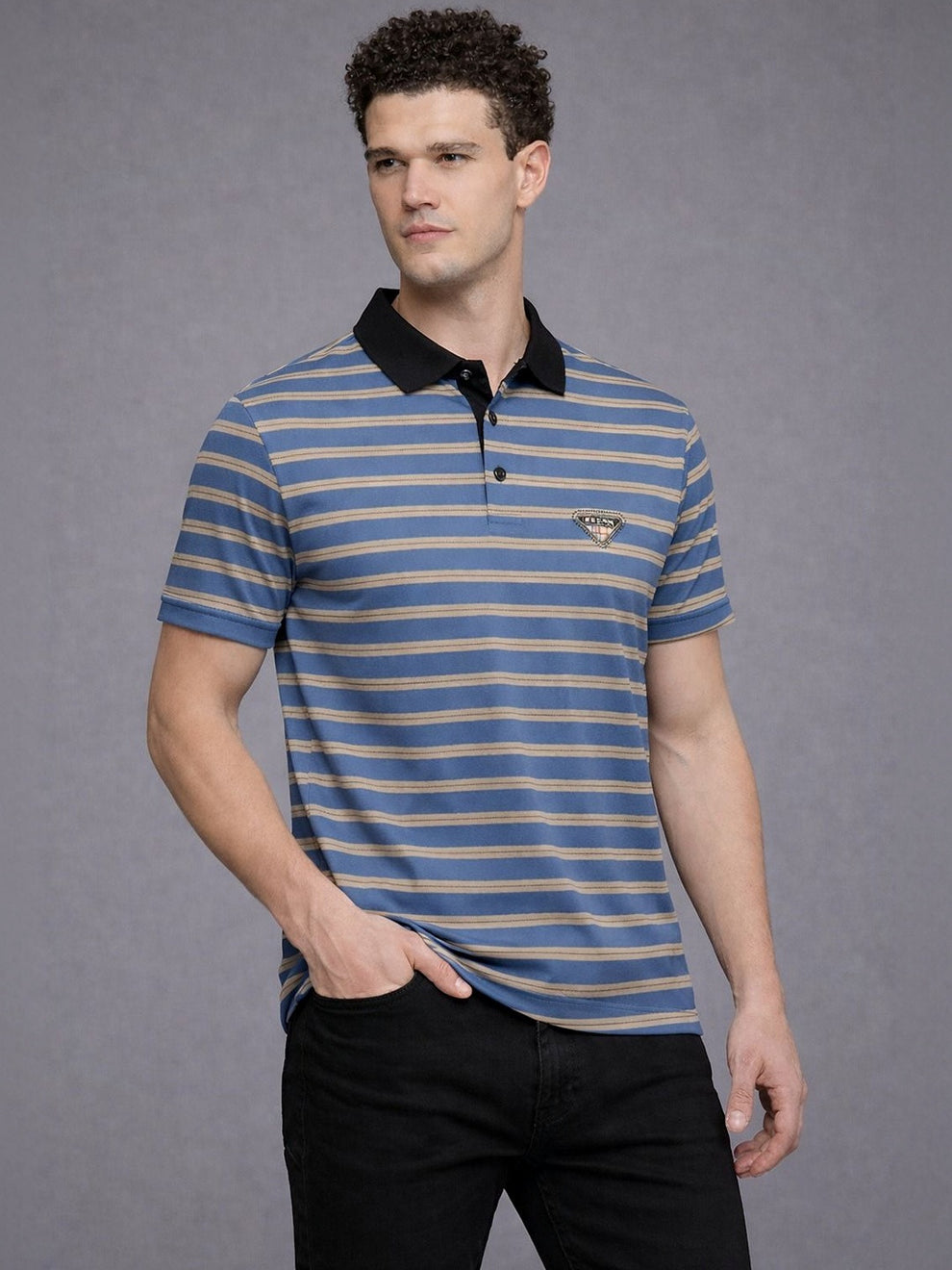 Man wearing a blue and beige striped polo shirt with a black collar on a gray background