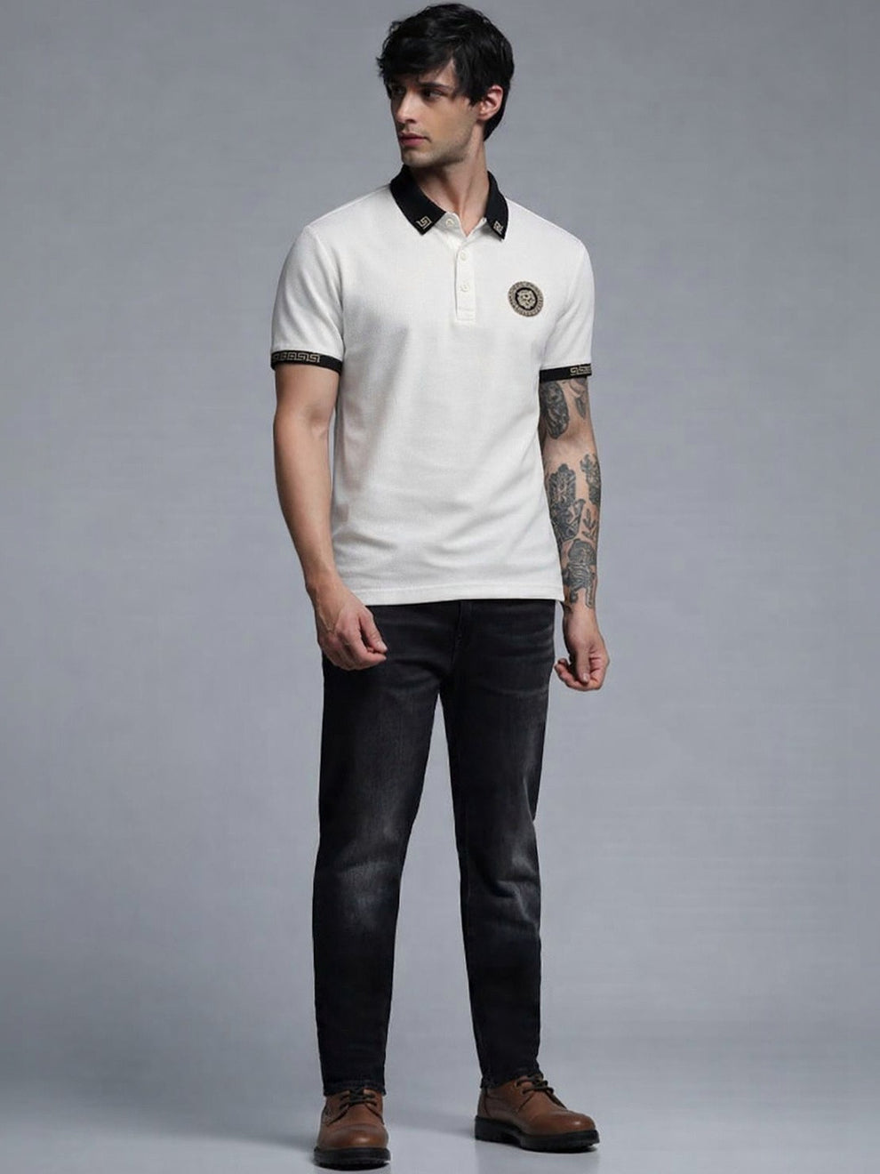 Man wearing a white polo shirt with black accents and dark jeans on a gray background
