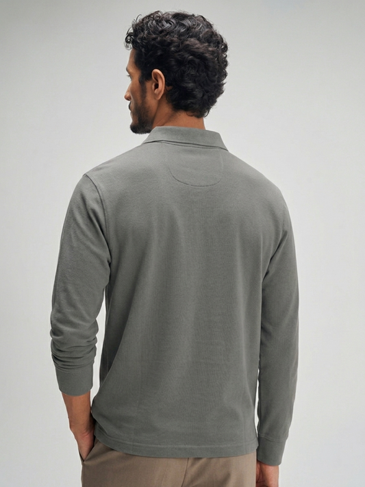Man wearing a gray long-sleeve shirt against a plain background