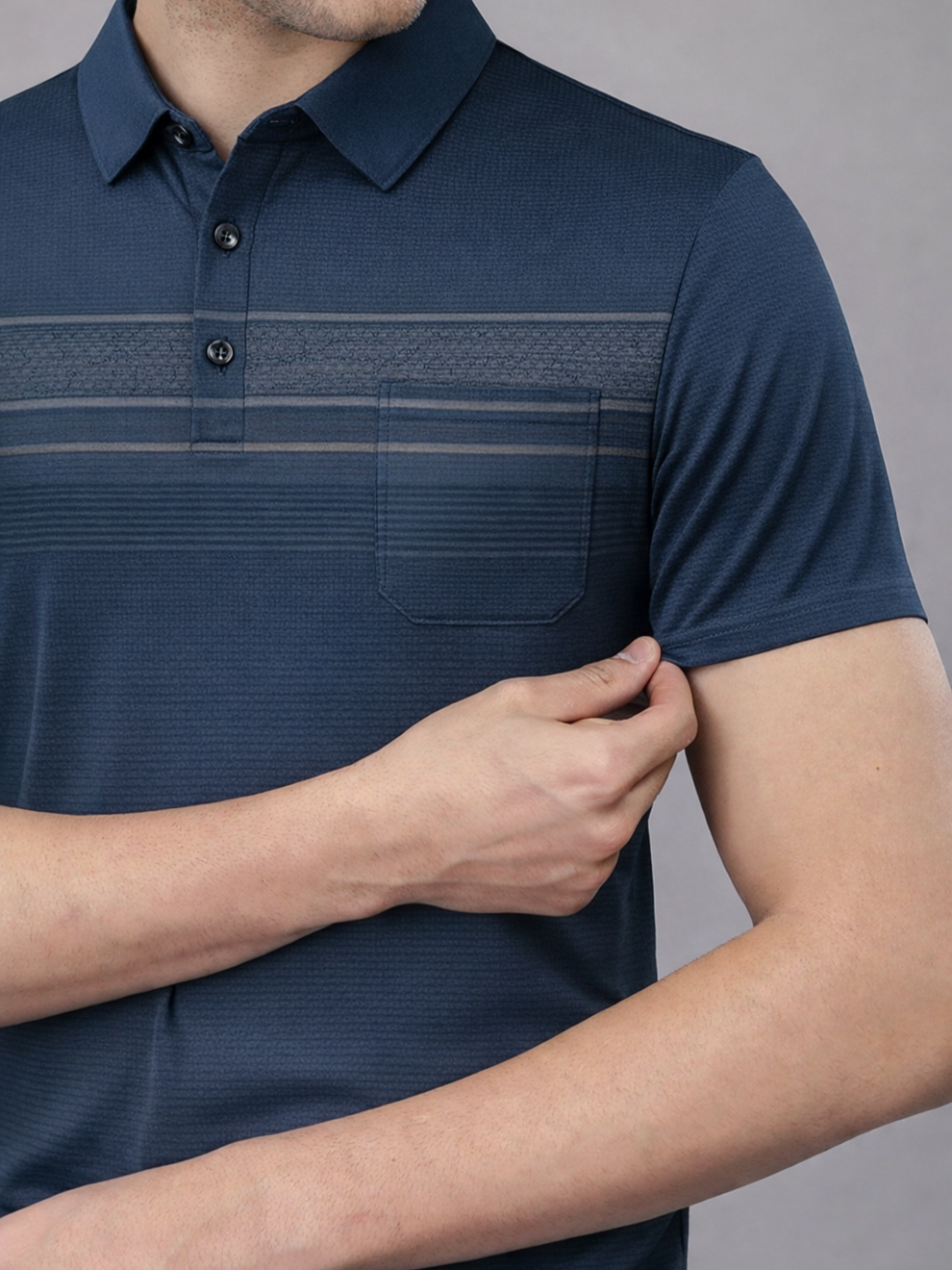 Navy blue polo shirt with a pocket on a gray background