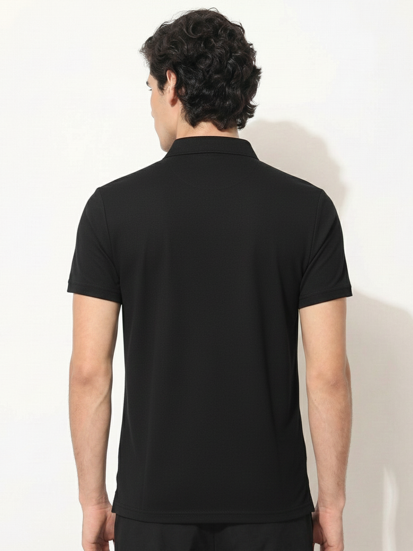 Person wearing a black polo shirt against a white background