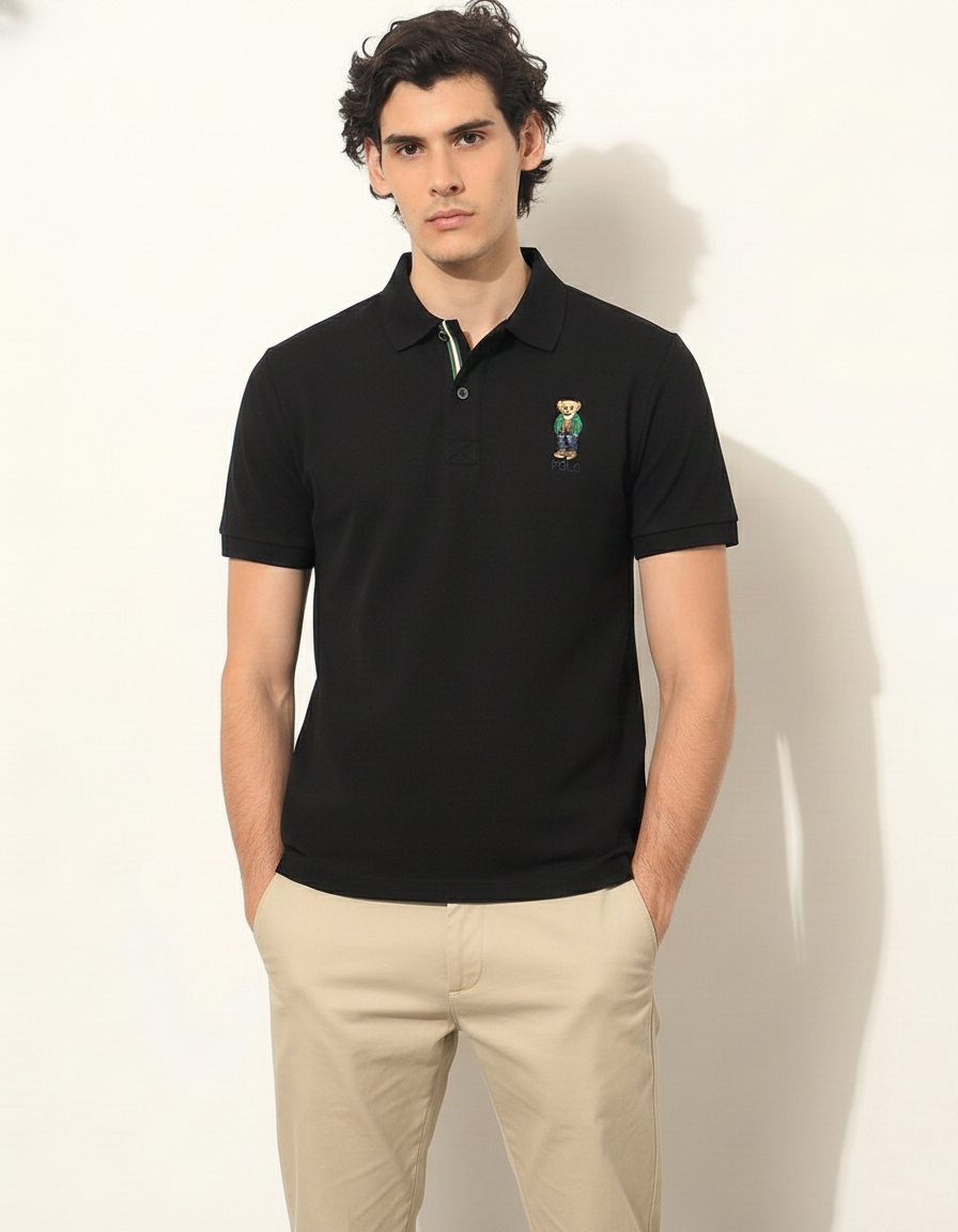 Man wearing a black polo shirt with a logo on a white background