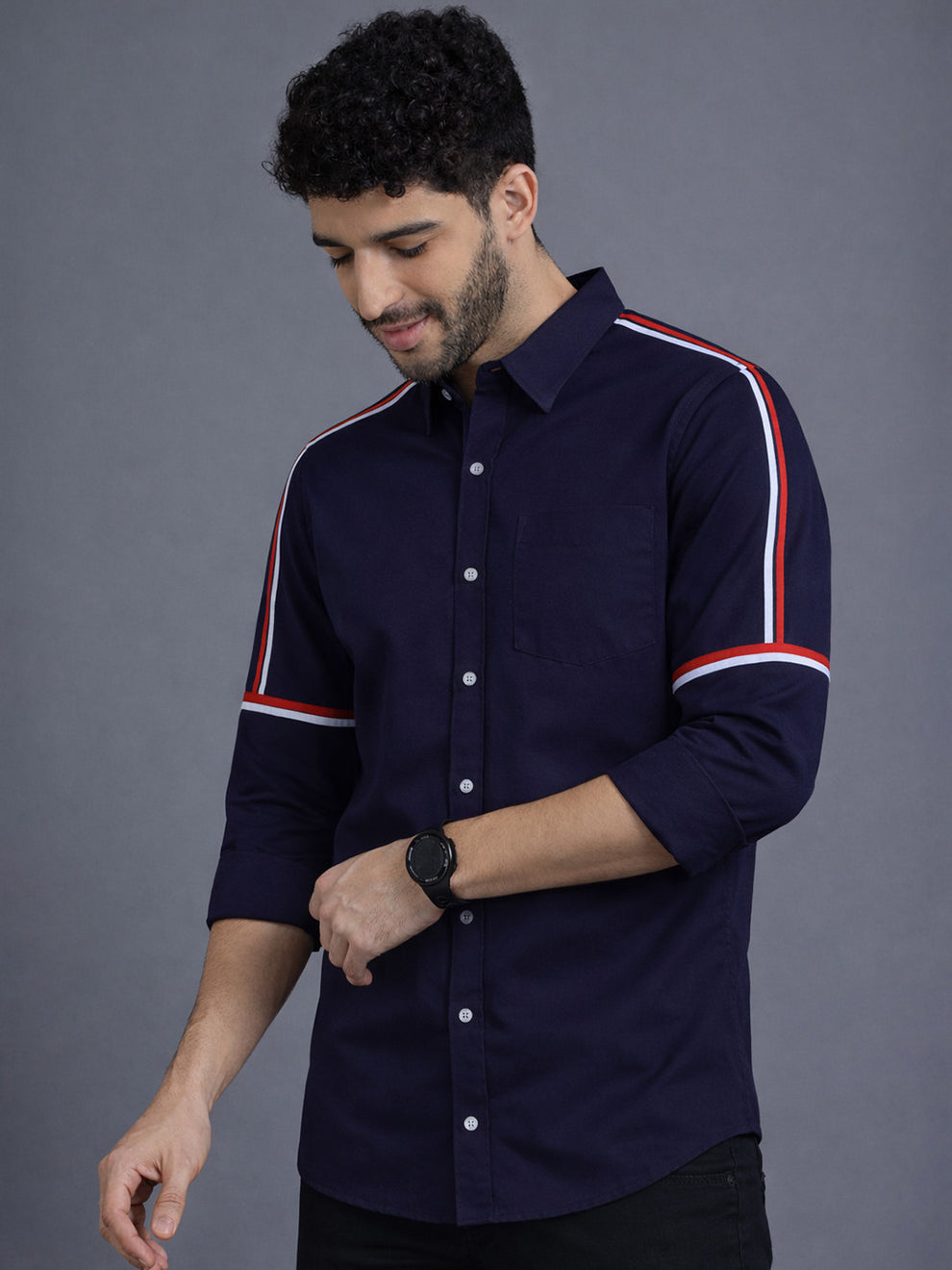 Man wearing a navy shirt with white and red stripes on a gray background