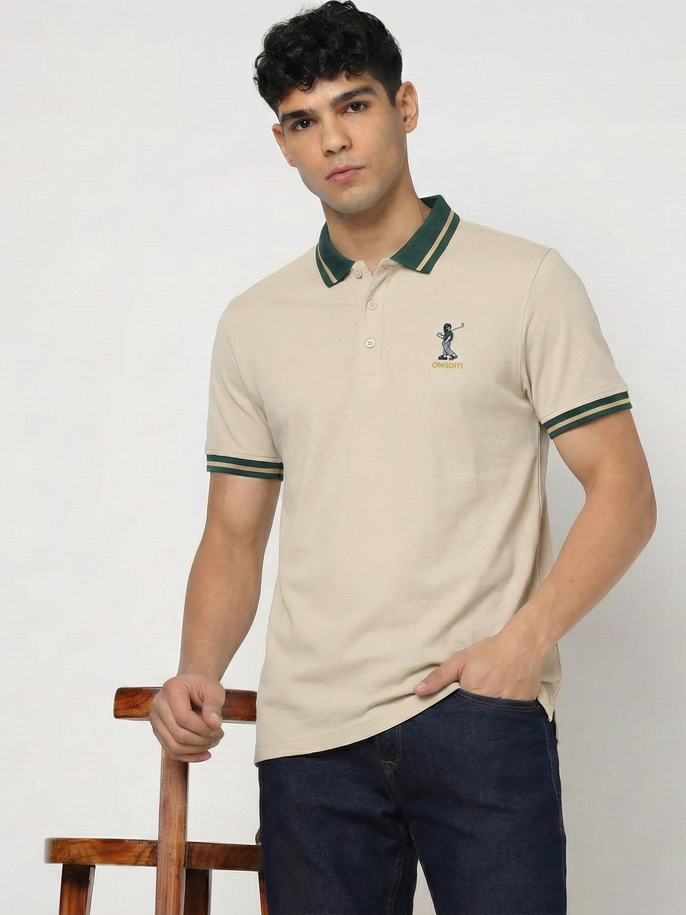 Man wearing a beige polo shirt with green accents against a white background