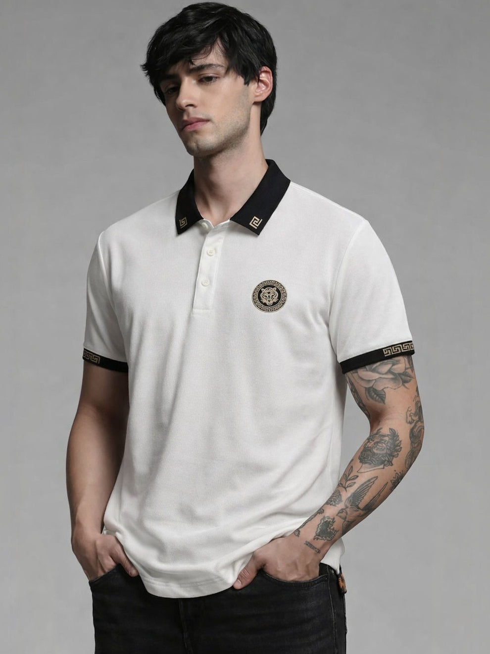 Man wearing a white polo shirt with black accents on a gray background