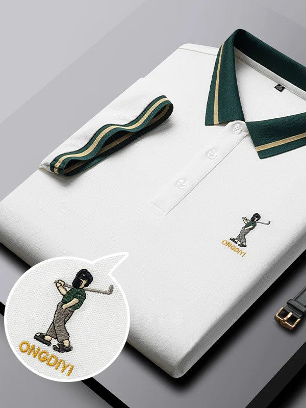 White polo shirt with green collar and embroidered design on a gray surface