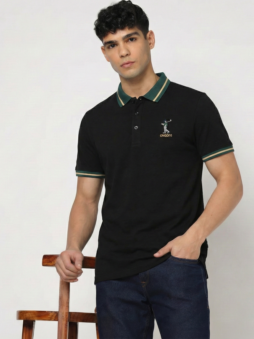 Man wearing a black polo shirt with a logo on a white background