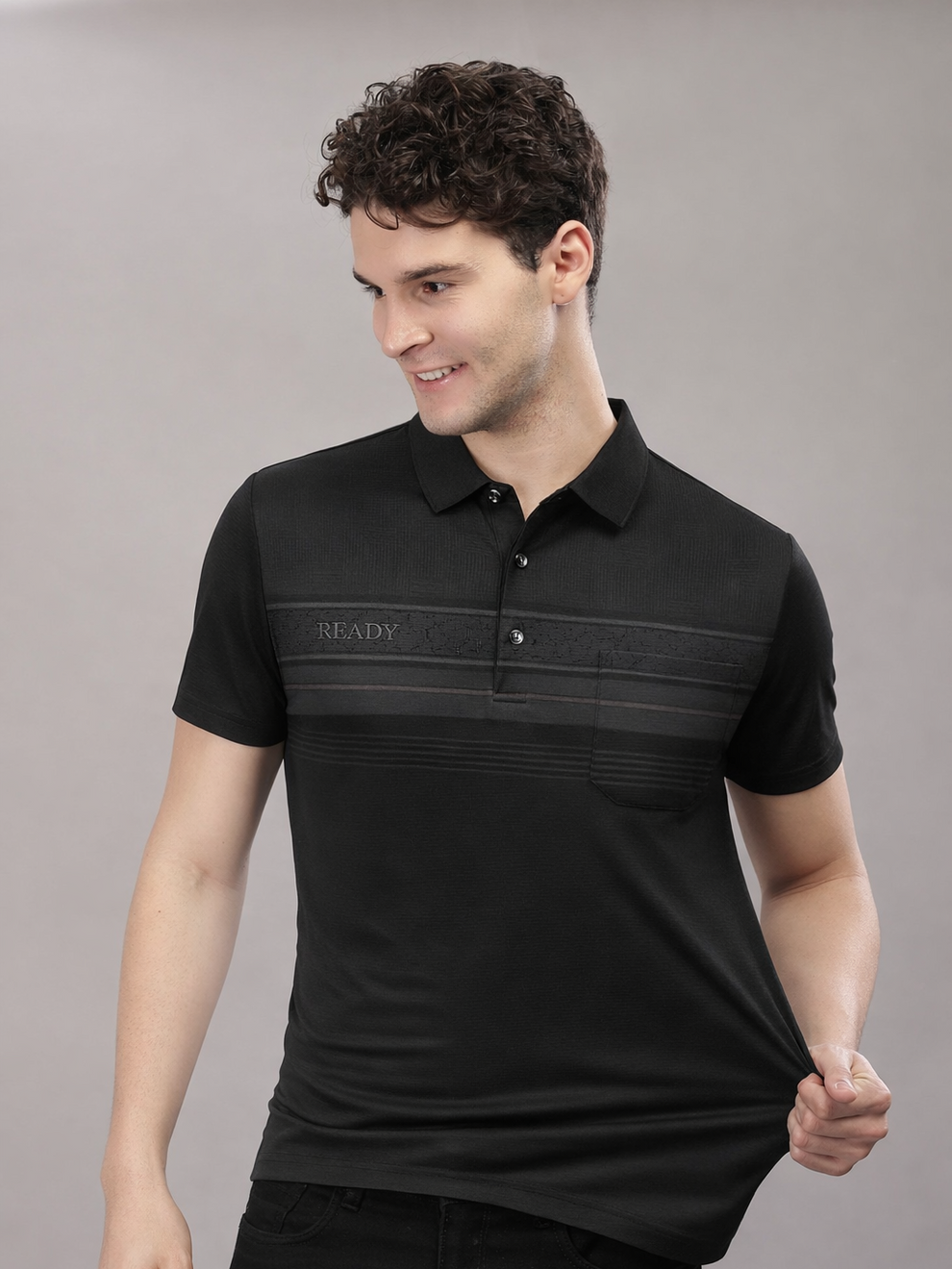 Man wearing a black polo shirt with 'BE READY' text on a gray background
