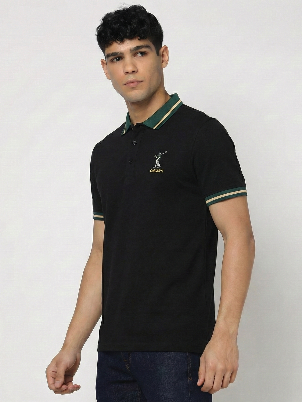 Man wearing a black polo shirt with green accents on a plain background