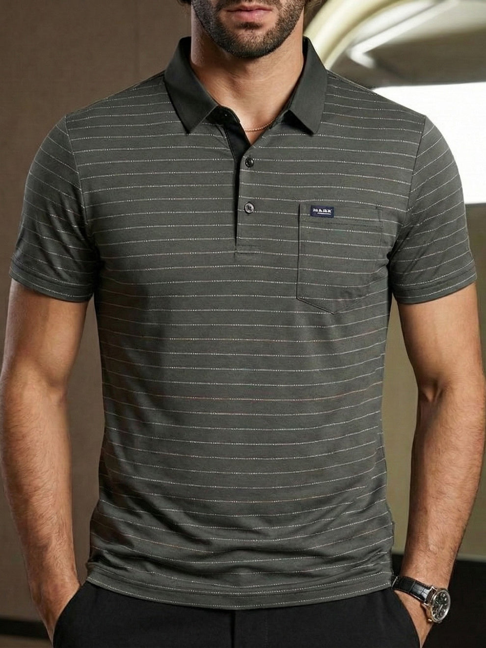Man wearing a gray striped polo shirt with a brand logo on a neutral background