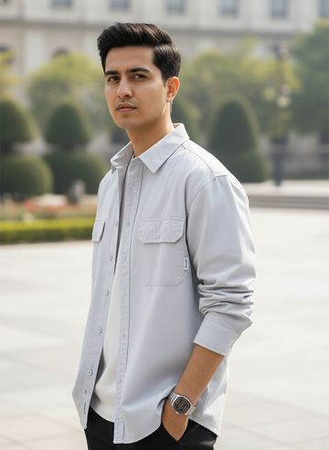 Man wearing a light gray shirt with a blurred background