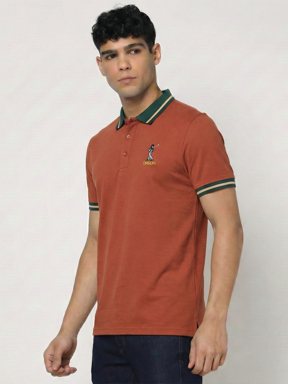 Man wearing a orange polo shirt with green accents on a plain background