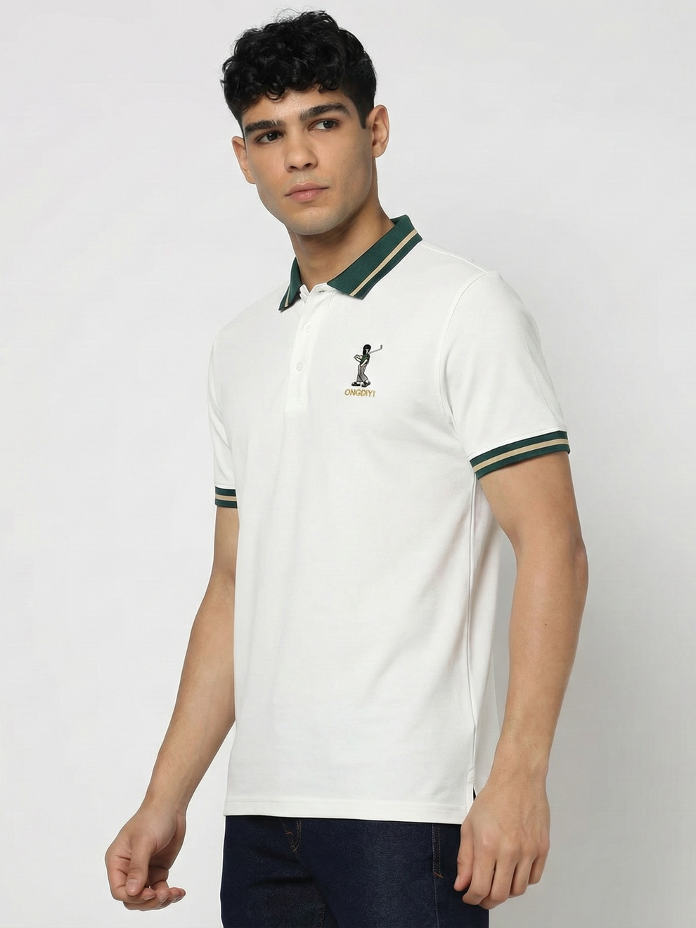 Man wearing a white polo shirt with green accents on a light gray background