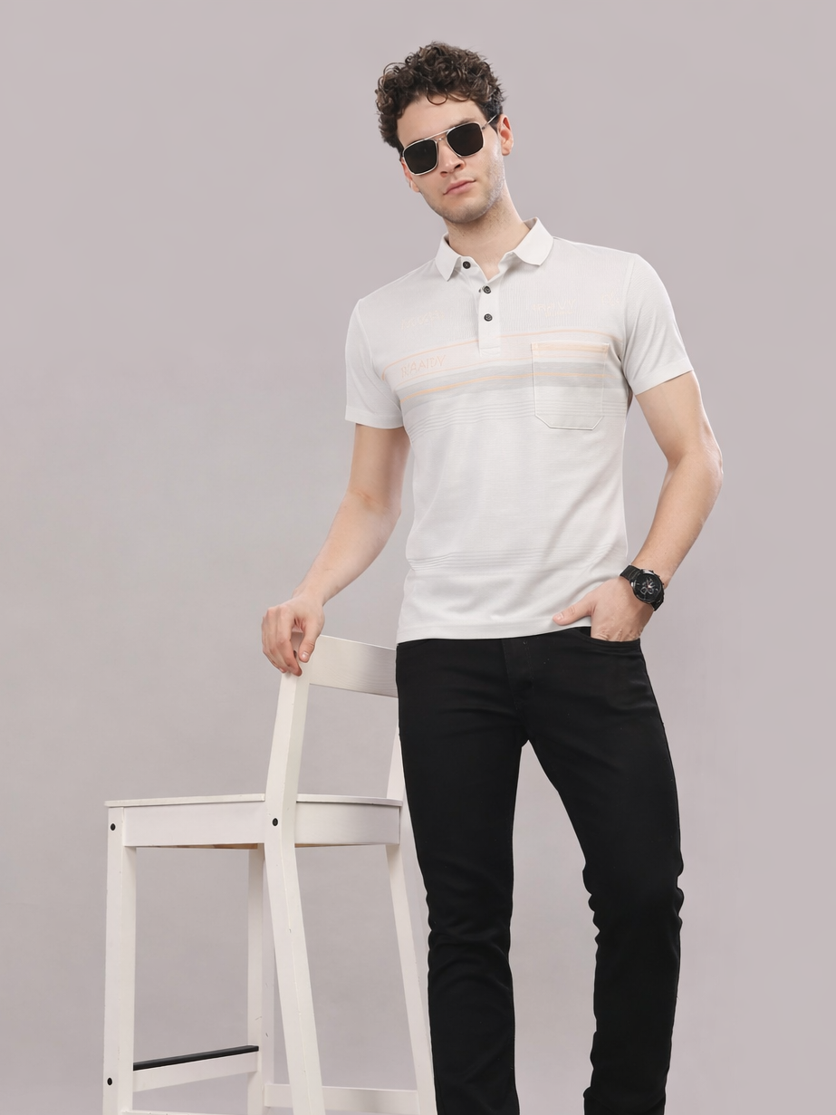 Man wearing a white polo shirt and black pants against a gray background