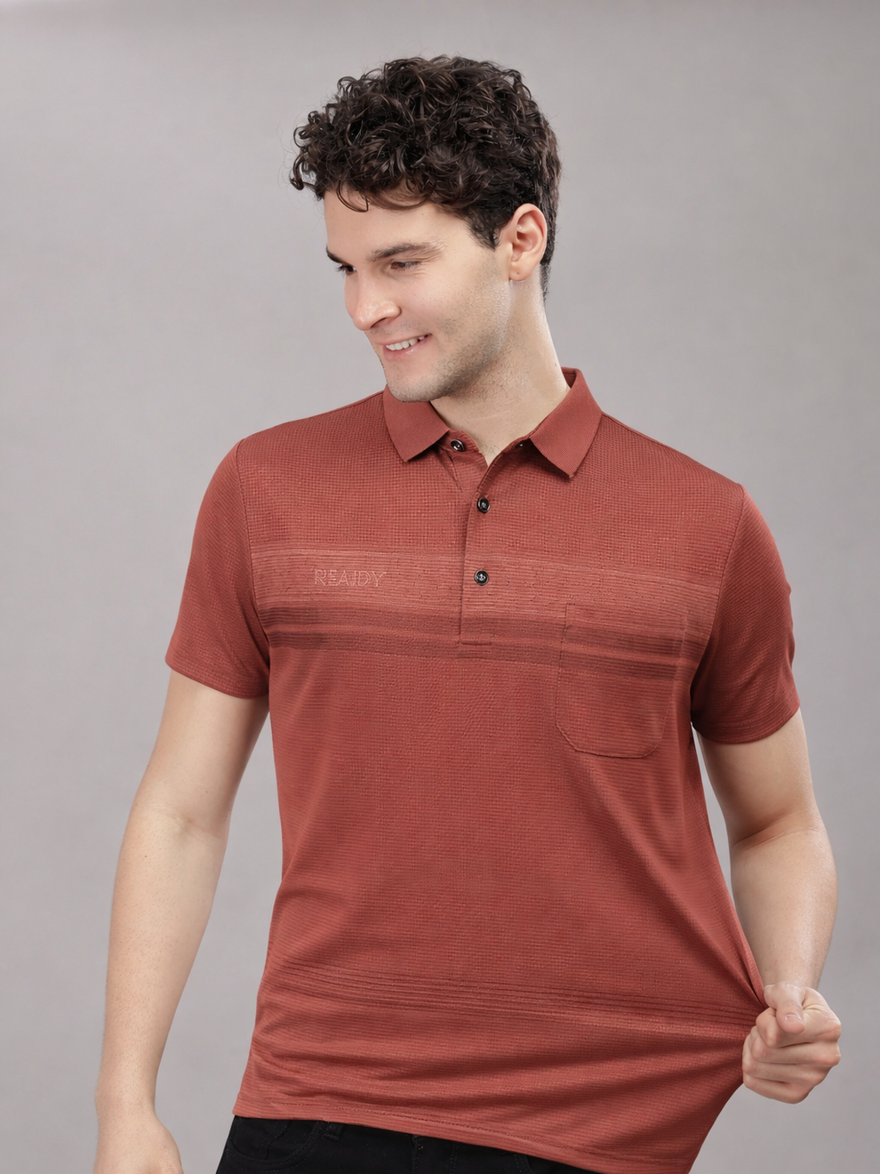 Man wearing a red polo tshirt against a gray background