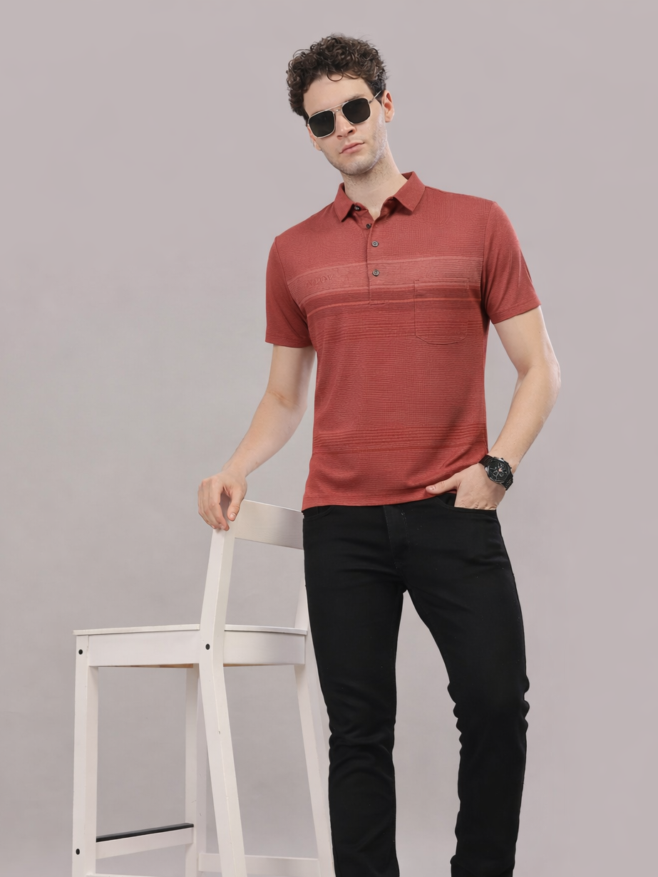 Man wearing a red polo shirt and black pants against a gray background