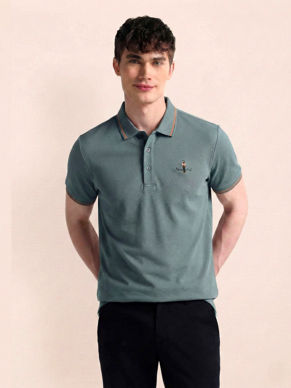 Man wearing a teal polo shirt with a small logo on a beige background