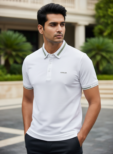 Man wearing a white polo shirt with a brand logo, standing outdoors.