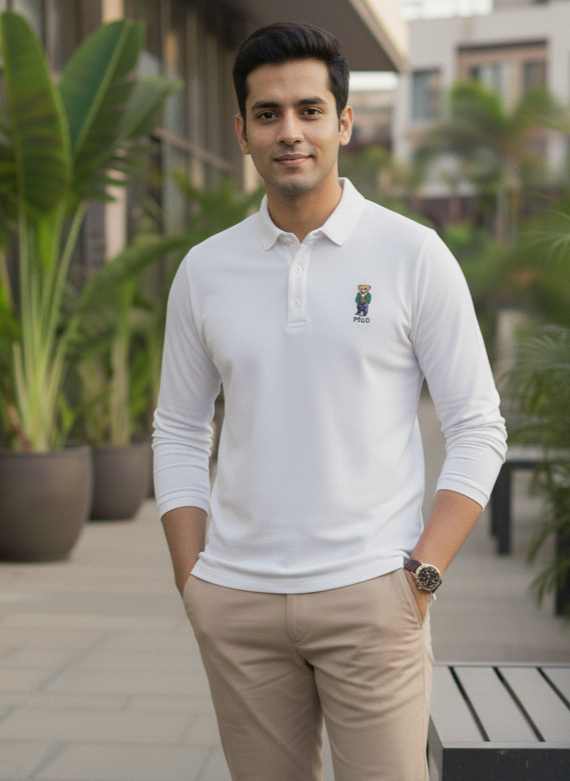 Man wearing a white polo shirt with a logo outdoors